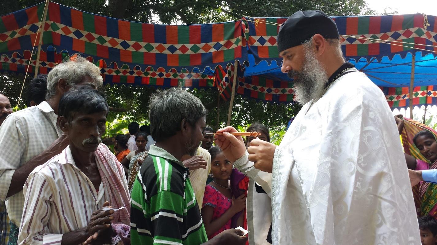 Fr. Athanasius anointing people before baptism.They are holding their name tags.